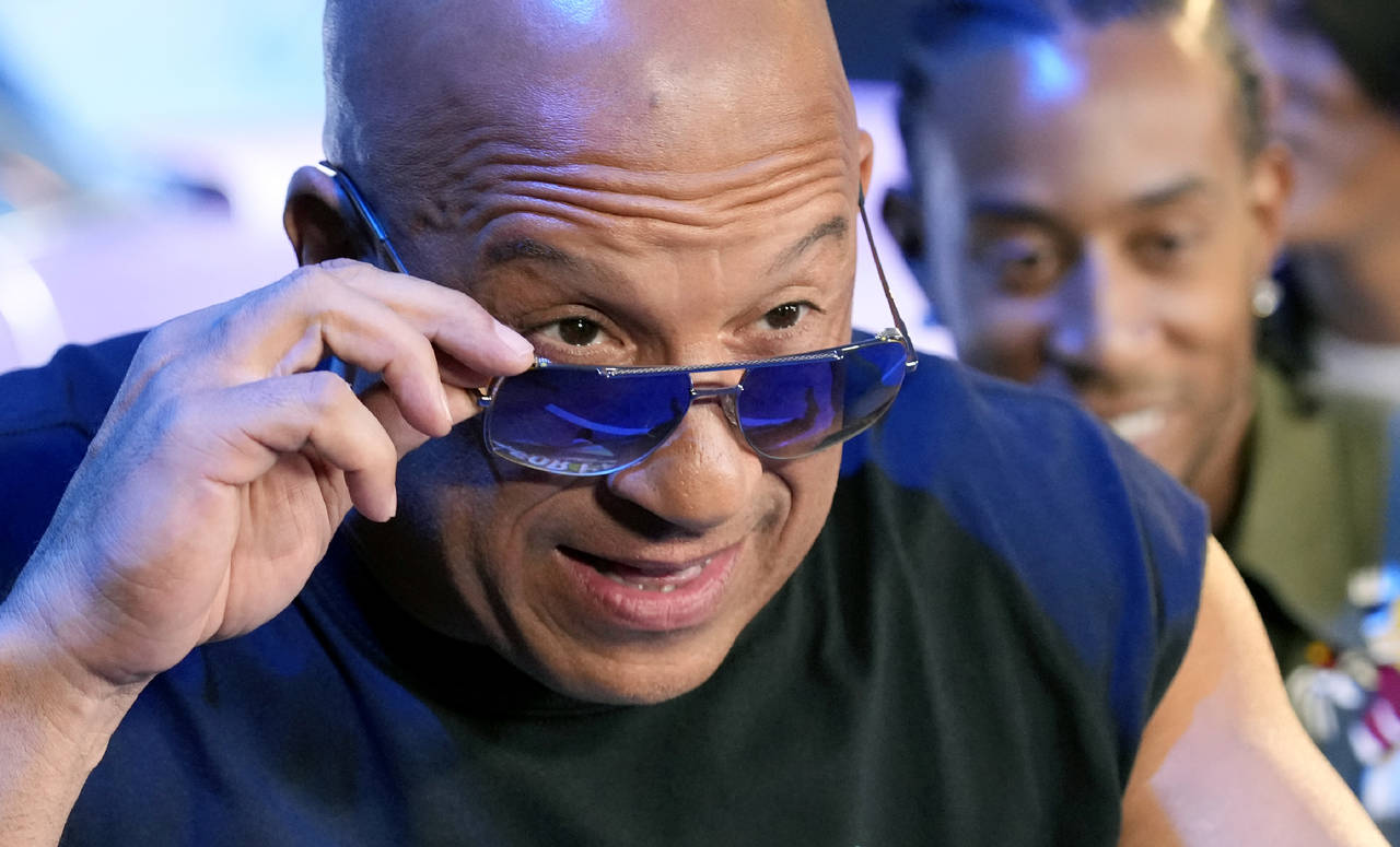 Vin Diesel, a cast member in the upcoming film "Fast X," peers over his sunglasses at photographers...
