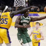 
              Milwaukee Bucks guard Jrue Holiday, center, shoots as Los Angeles Lakers forward Wenyen Gabriel, left, and guard Austin Reaves defend during the second half of an NBA basketball game Thursday, Feb. 9, 2023, in Los Angeles. (AP Photo/Mark J. Terrill)
            