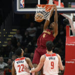 
              Cleveland Cavaliers forward Evan Mobley (4) dunks over Washington Wizards guard Monte Morris (22) and forward Deni Avdija (9) during the first half of an NBA basketball game, Monday, Feb. 6, 2023, in Washington. (AP Photo/Nick Wass)
            