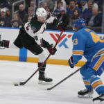 
              Arizona Coyotes' Christian Fischer, left, shoots past St. Louis Blues' Calle Rosen (43) during the first period of an NHL hockey game Saturday, Feb. 11, 2023, in St. Louis. (AP Photo/Jeff Roberson)
            