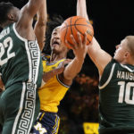 
              Michigan guard Kobe Bufkin attempts a layup as Michigan State center Mady Sissoko (22) and forward Joey Hauser (10) defend during the second half of an NCAA college basketball game, Saturday, Feb. 18, 2023, in Ann Arbor, Mich. (AP Photo/Carlos Osorio)
            