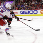 
              New York Rangers right wing Julien Gauthier (12) shoots the puck past Carolina Hurricanes defenseman Brett Pesce during the first period of an NHL hockey game, Saturday, Feb. 11, 2023, in Raleigh, N.C. (AP Photo/Chris Seward)
            