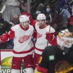 
              Detroit Red Wings' Pius Suter, back left, and Filip Zadina celebrate after Suter's goal against Vancouver Canucks goalie Collin Delia, front right, during the third period of an NHL hockey game in Vancouver, British Columbia, Monday, Feb. 13, 2023. (Darryl Dyck/The Canadian Press via AP)
            
