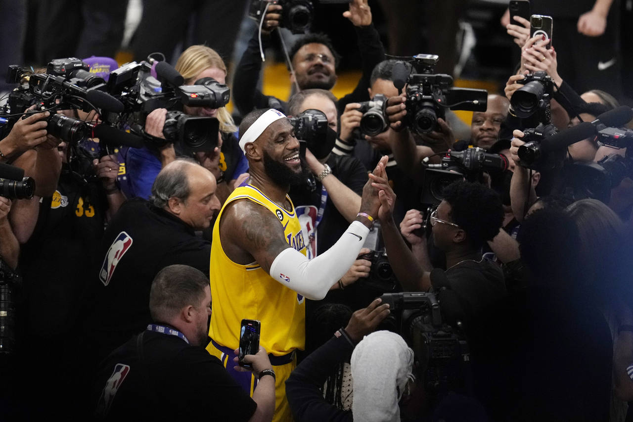Los Angeles Lakers forward LeBron James is surrounded by cameras after scoring to pass Kareem Abdul...