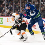 
              Vancouver Canucks' Tyler Myers, right, tries to check Philadelphia Flyers' Travis Konecny during the first period of an NHL hockey game Saturday, Feb. 18, 2023, in Vancouver, British Columbia. (Rich Lam/The Canadian Press via AP)
            