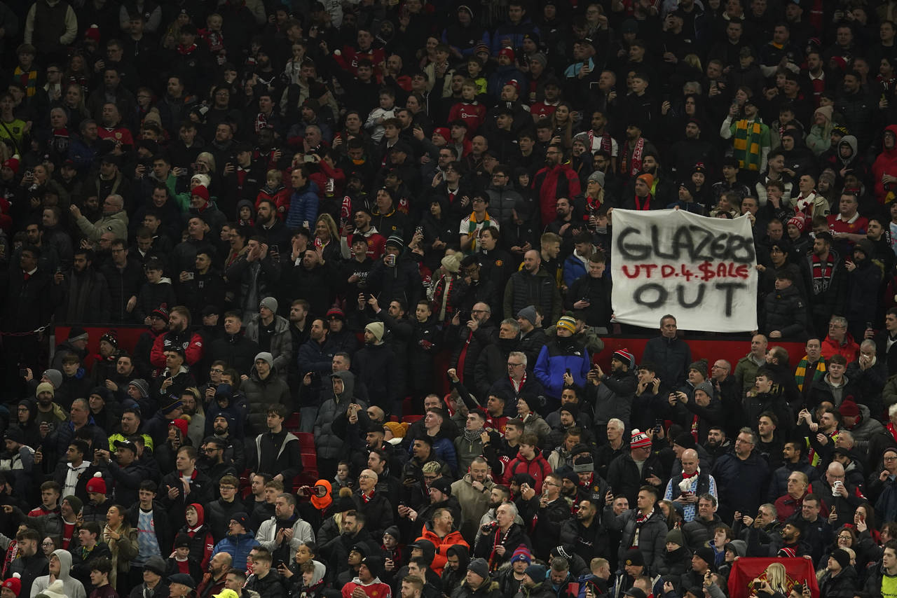 An anti-Glazer family banner is held up by members of the crowd before the English League Cup semif...