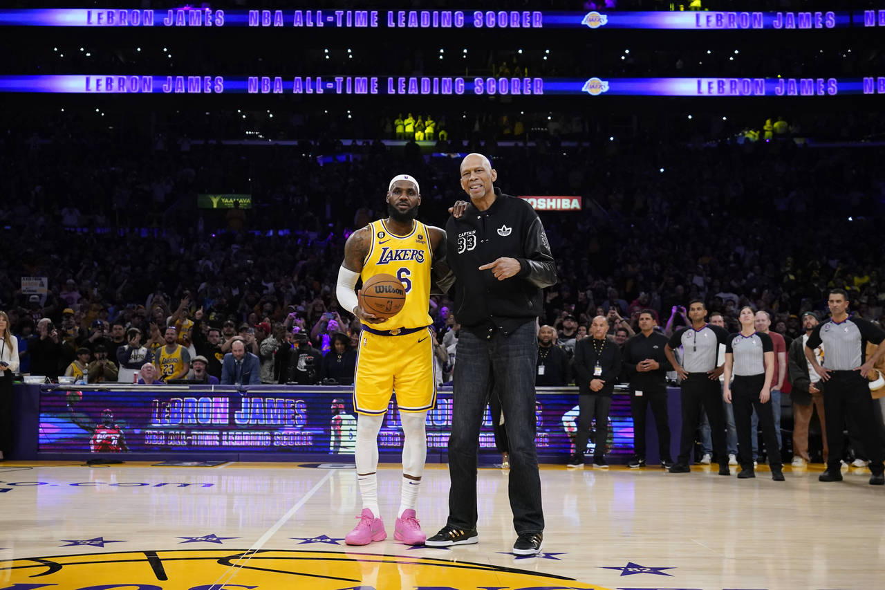 Los Angeles Lakers forward LeBron James, left, poses with Kareem Abdul-Jabbar after passing Abdul-J...
