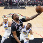 
              Los Angeles Clippers forward Norman Powell, center, shoots as Golden State Warriors guard Moses Moody, left, and forward Jonathan Kuminga defend during the first half of an NBA basketball game Tuesday, Feb. 14, 2023, in Los Angeles. (AP Photo/Mark J. Terrill)
            