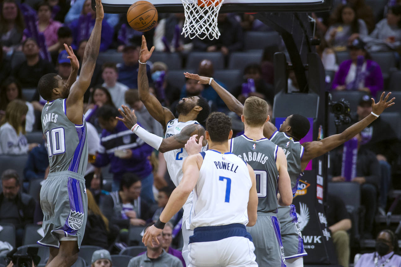 Dallas Mavericks guard Kyrie Irving (2) shoots as Sacramento Kings' Harrison Barnes, left, and De'A...