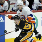 
              PIttsburgh Penguins left wing Drew O'Connor (10) reaches for the puck in front of New York Islanders defenseman Noah Dobson (8) during the third period of an NHL hockey game in Pittsburgh, Monday, Feb. 20, 2023. (AP Photo/Matt Freed)
            