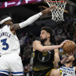 
              Golden State Warriors guard Klay Thompson (11) looks to pass while defended by Minnesota Timberwolves forward Jaden McDaniels (3), left, and forward Kyle Anderson during the second half of an NBA basketball game, Wednesday, Feb. 1, 2023, in Minneapolis. (AP Photo/Abbie Parr)
            