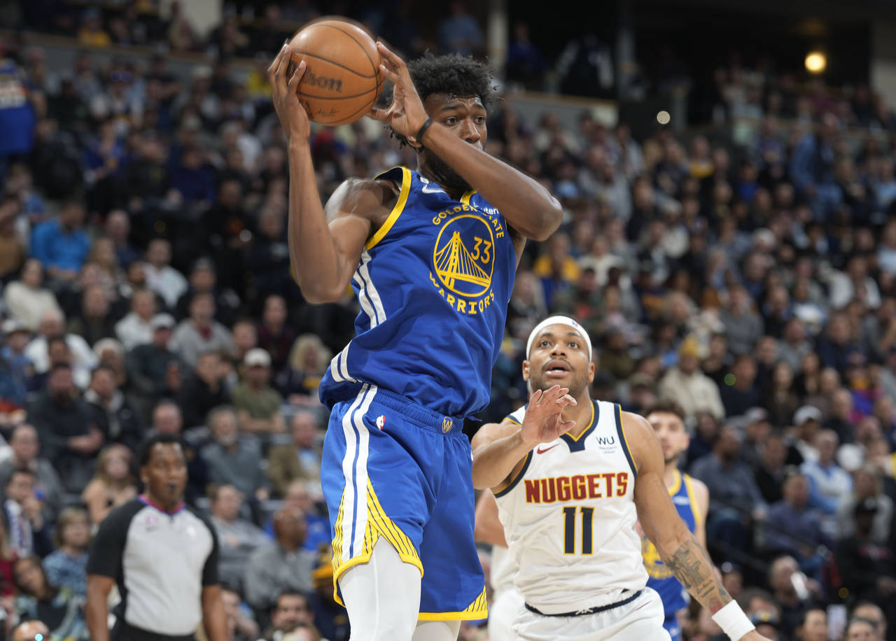Golden State Warriors center James Wiseman, front, pulls in a rebound in front of Denver Nuggets fo...