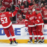 
              Detroit Red Wings center Dylan Larkin, center, celebrates his goal with Moritz Seider (53) and David Perron (57) in the second period of an NHL hockey game against the Calgary Flames Thursday, Feb. 9, 2023, in Detroit. (AP Photo/Paul Sancya)
            