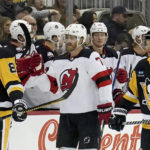 
              New Jersey Devils teammates congratulate defenseman Dougie Hamilton (7) after he scored against the Pittsburgh Penguins during the second period of an NHL hockey game in Pittsburgh, Saturday, Feb. 18, 2023. (AP Photo/Matt Freed)
            