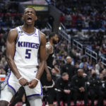 
              Sacramento Kings guard De'Aaron Fox, left, celebrates after scoring as Los Angeles Clippers forward Marcus Morris Sr. stands in the background during the second half of an NBA basketball game Friday, Feb. 24, 2023, in Los Angeles. (AP Photo/Mark J. Terrill)
            