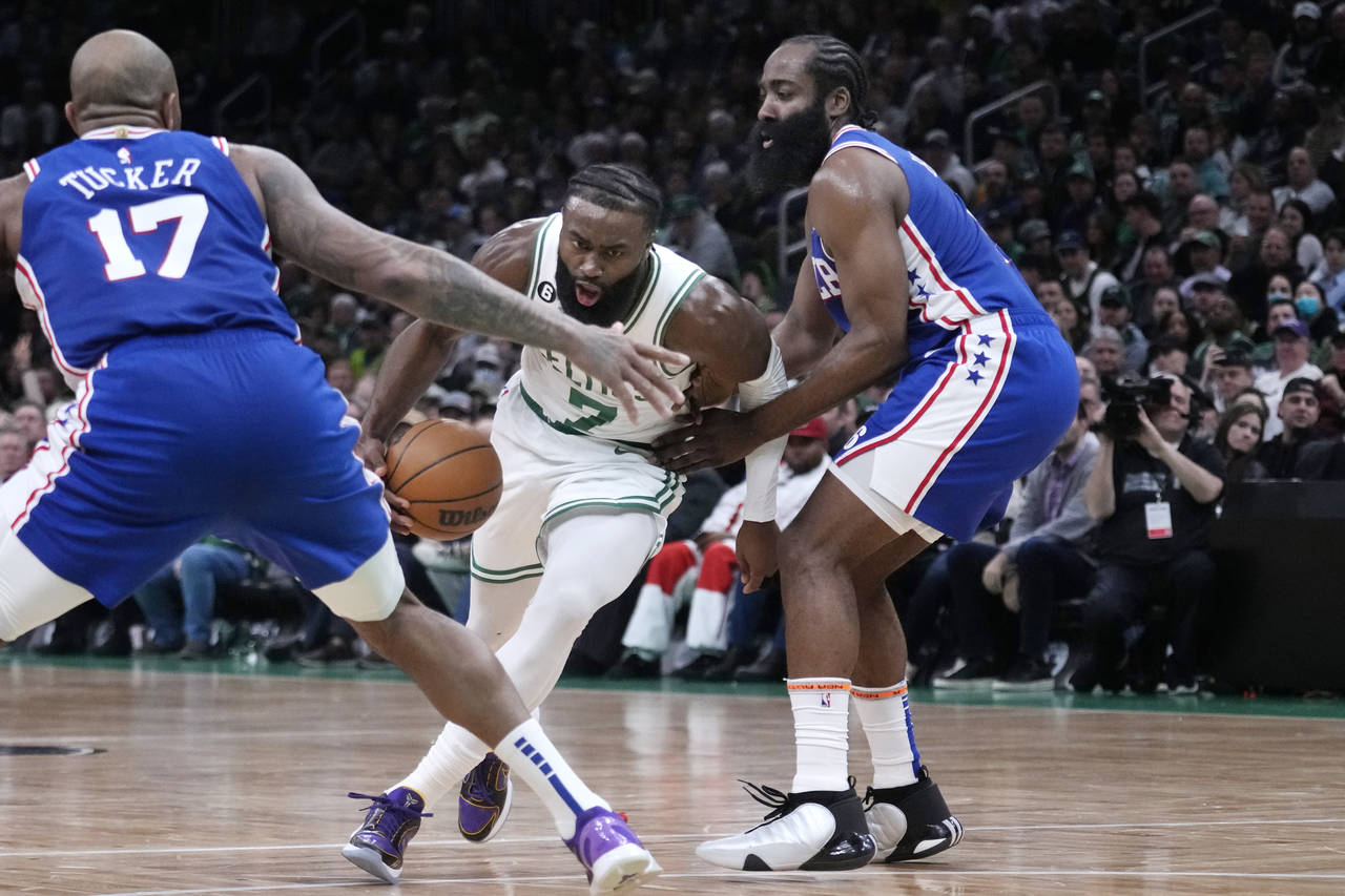 Boston Celtics guard Jaylen Brown (7) drives to the basket between Philadelphia 76ers guard James H...