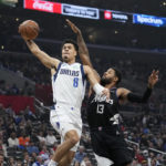 
              Dallas Mavericks guard Josh Green, left, shoots as Los Angeles Clippers forward Paul George defends during the first half of an NBA basketball game Wednesday, Feb. 8, 2023, in Los Angeles. (AP Photo/Mark J. Terrill)
            