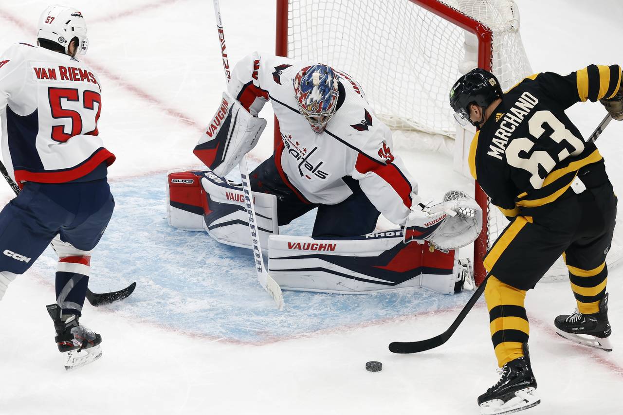 Boston Bruins' Brad Marchand (63) attempts to shoot against Washington Capitals' Darcy Kuemper (35)...