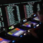 
              A person gambles as betting odds for NFL football's Super Bowl are displayed on monitors at the Circa resort and casino sports book Friday, Feb. 3, 2023, in Las Vegas. (AP Photo/John Locher)
            