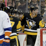 
              Pittsburgh Penguins left wing Jason Zucker (16), center, celebrates his goal against the New York Islanders with right wing Bryan Rust (17), left, and center Jeff Carter (787), right, during the second period of an NHL hockey game in Pittsburgh, Monday, Feb. 20, 2023. (AP Photo/Matt Freed)
            