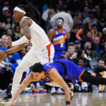 
              Los Angeles Clippers' Terance Mann (14) controls the ball next to a diving Phoenix Suns' Devin Booker (1) during the first half of an NBA basketball game Thursday, Feb. 16, 2023, in Phoenix. (AP Photo/Darryl Webb)
            