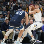 
              Denver Nuggets forward Michael Porter Jr., right, pulls in the ball as Minnesota Timberwolves center Luka Garza defends during the second half of an NBA basketball game Tuesday, Feb. 7, 2023, in Denver. (AP Photo/David Zalubowski)
            