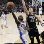 
              Philadelphia 76ers guard Shake Milton (18) drives to the basket against San Antonio Spurs forward Zach Collins (23) during the first half of an NBA basketball game in San Antonio, Friday, Feb. 3, 2023. (AP Photo/Eric Gay)
            