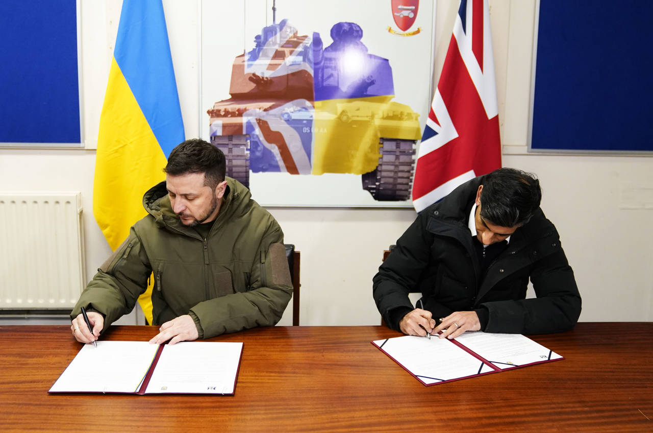 Ukrainian President Volodymyr Zelensky, left, and British Prime Minister Rishi Sunak sign a declara...