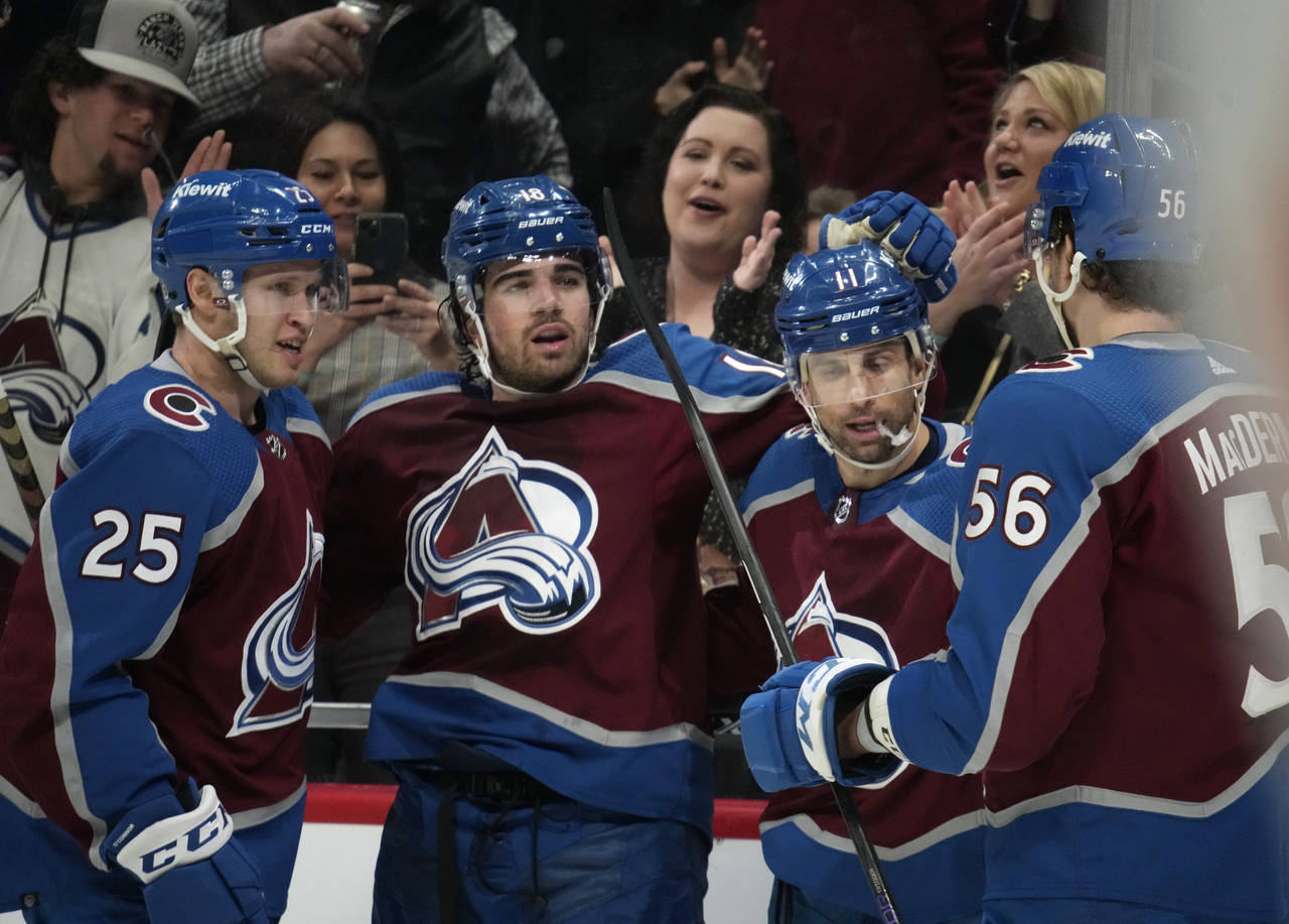 Colorado Avalanche center Alex Newhook, second from left, is congratulated after scoring a goal aga...