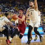 
              Nebraska guard Keisei Tominaga (30) drives towards the basket as Michigan guard Jett Howard (13) and center Hunter Dickinson (1) defend during the first half of an NCAA college basketball game, Wednesday, Feb. 8, 2023, in Ann Arbor, Mich. (AP Photo/Carlos Osorio)
            