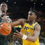 
              Michigan State guard Tyson Walker reaches in on Michigan forward Tarris Reed Jr. (32) during the second half of an NCAA college basketball game, Saturday, Feb. 18, 2023, in Ann Arbor, Mich. (AP Photo/Carlos Osorio)
            