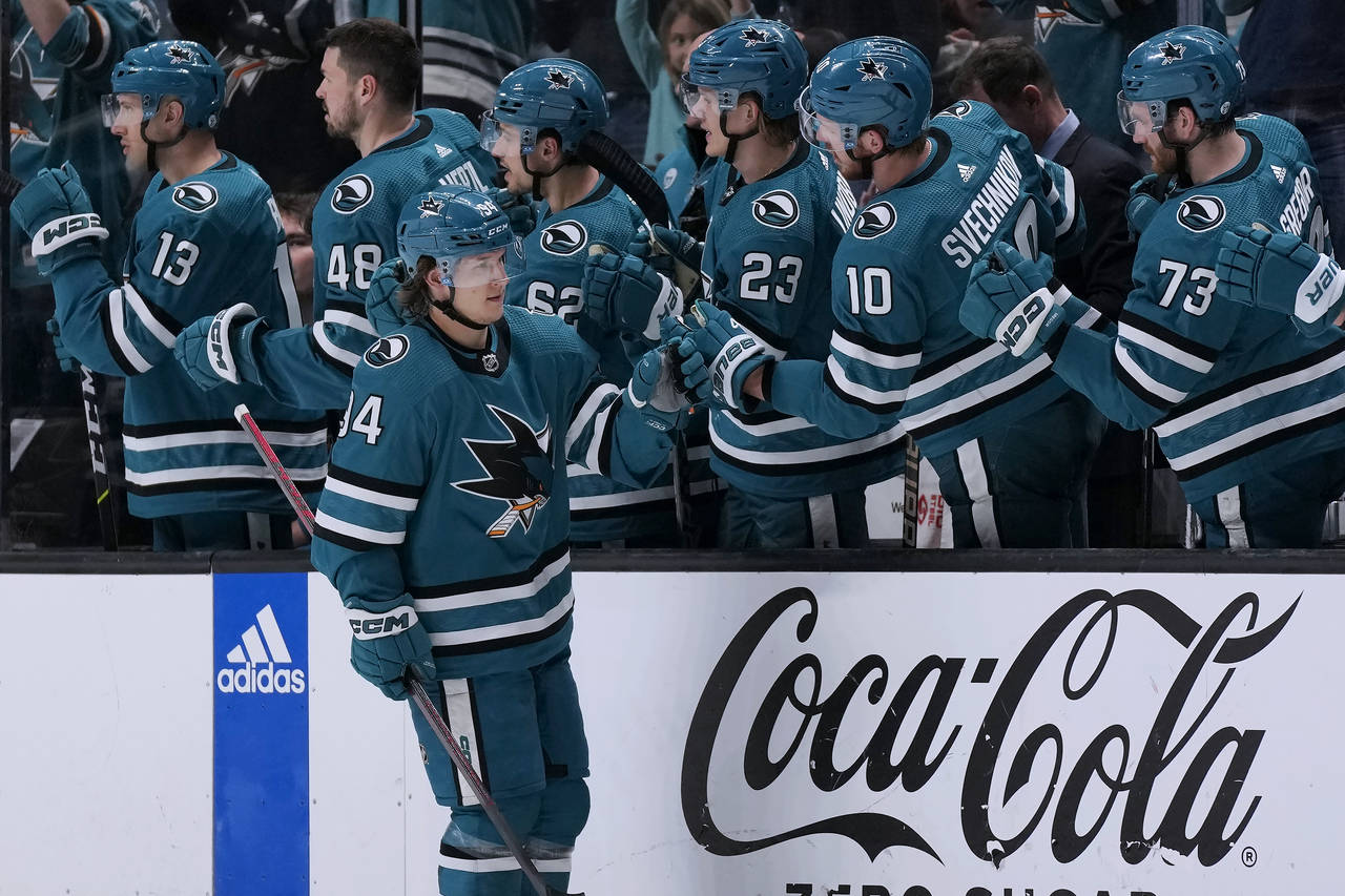 San Jose Sharks left wing Alexander Barabanov, foreground, is congratulated by teammates after scor...