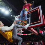 
              Students climb a rim as a crowd rushes the court after Maryland defeated Purdue 68-54 during an NCAA college basketball game, Thursday, Feb. 16, 2023, in College Park, Md. (AP Photo/Julio Cortez)
            