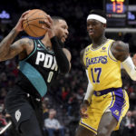 
              Portland Trail Blazers guard Damian Lillard, left, looks to get past Los Angeles Lakers guard Dennis Schroder, right, during the first half of an NBA basketball game in Portland, Ore., Monday, Feb. 13, 2023. (AP Photo/Steve Dykes)
            