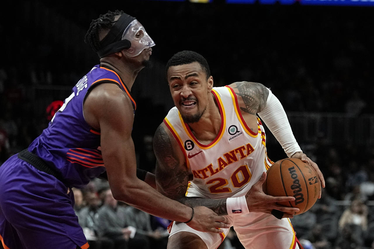 Atlanta Hawks forward John Collins (20) works against Phoenix Suns forward Josh Okogie, left, durin...