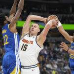 
              Denver Nuggets center Nikola Jokic, center, loses control of the ball as Golden State Warriors forward Andrew Wiggins, left, and guard Jordan Poole defend in the first half of an NBA basketball game Thursday, Feb. 2, 2023, in Denver. (AP Photo/David Zalubowski)
            