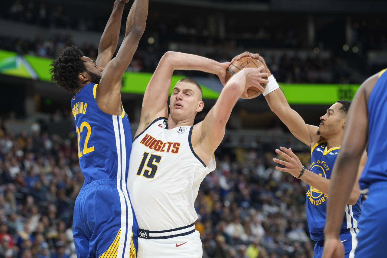 Denver Nuggets center Nikola Jokic, center, loses control of the ball as Golden State Warriors forw...
