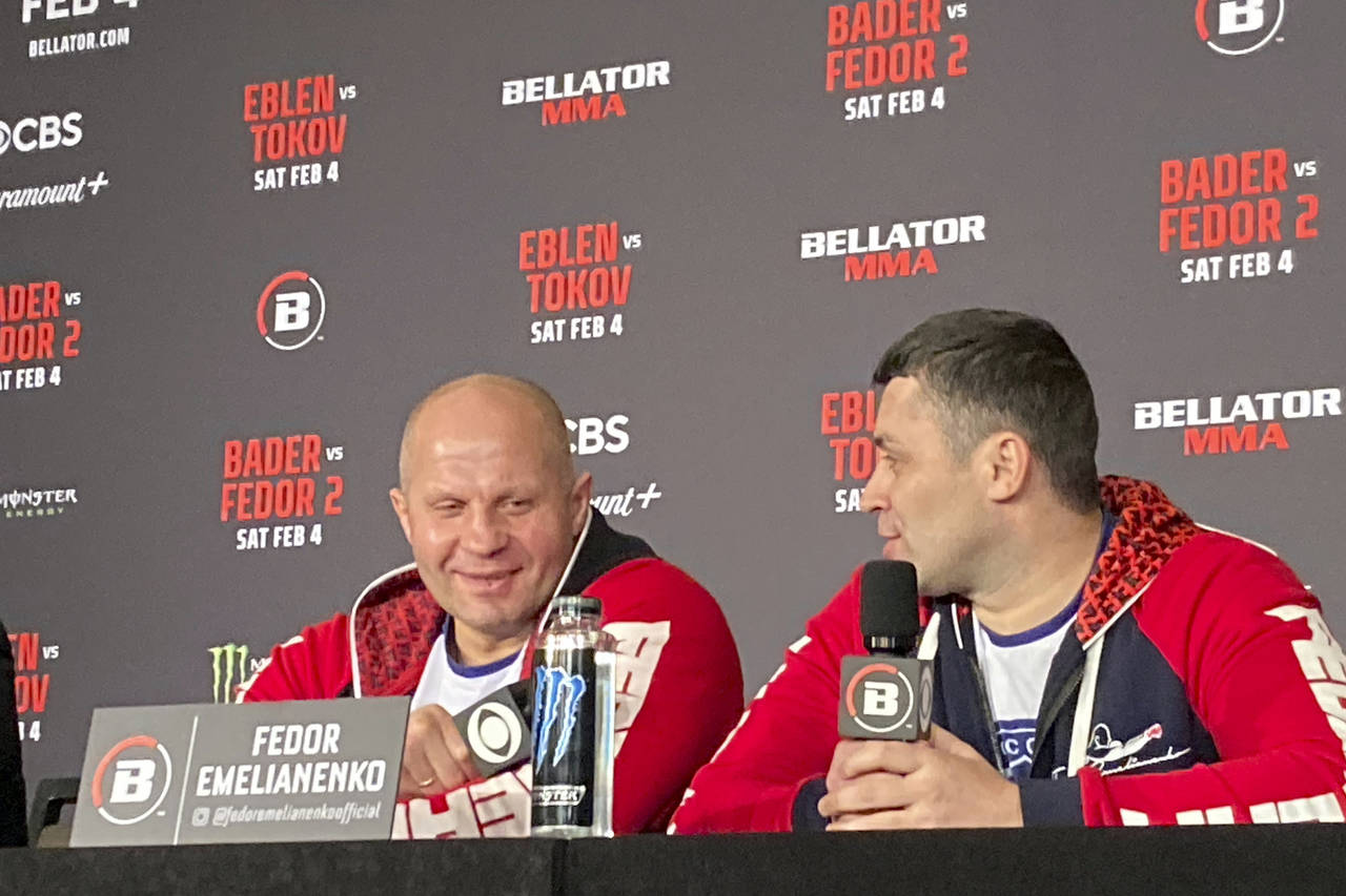 Fedor Emelianenko, left, laughs at a comment by interpreter Georgiy Litvinov during a news conferen...