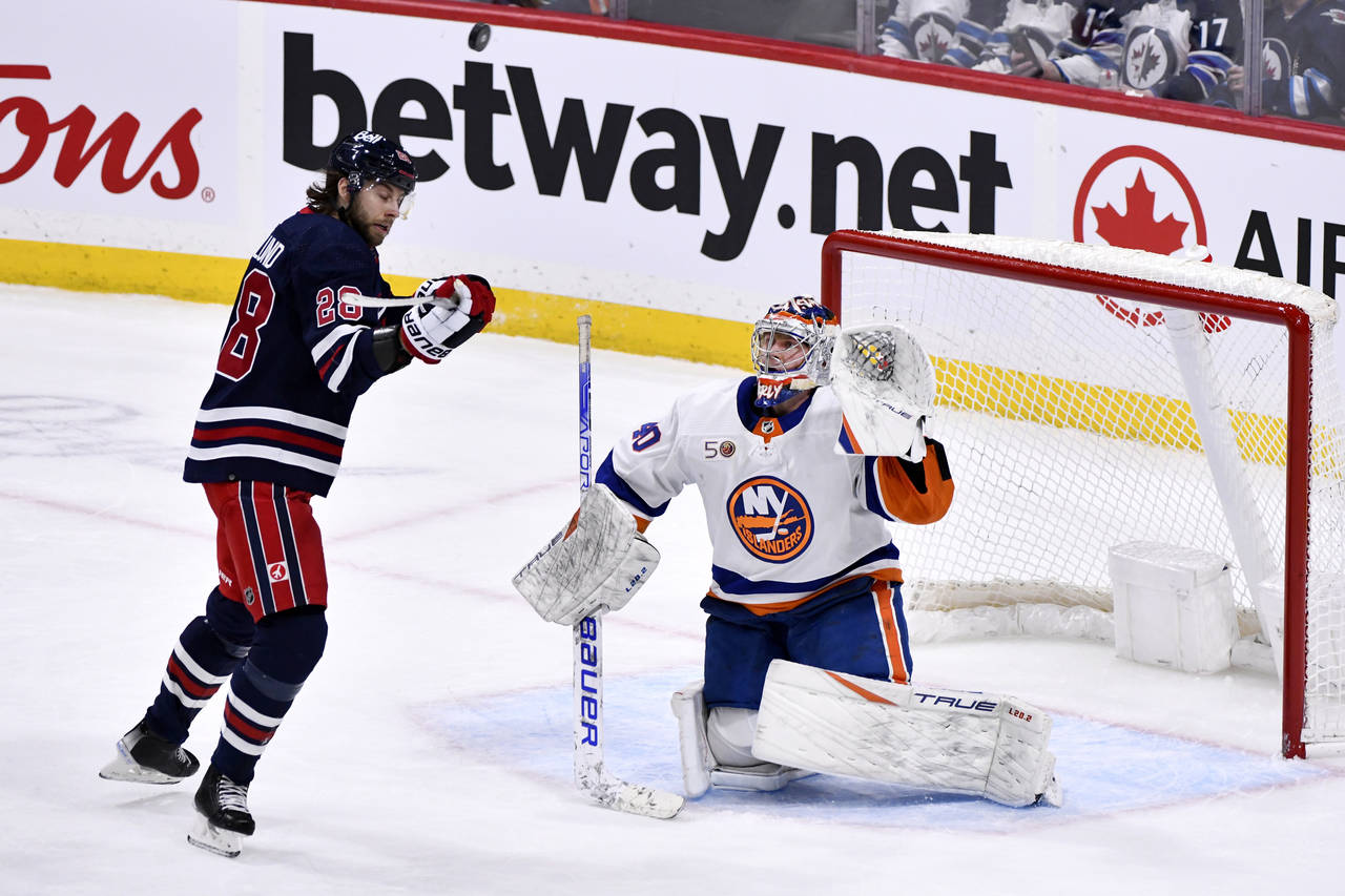 New York Islanders goaltender Semyon Varlamov (40) and Winnipeg Jets Kevin Stenlund (28) watch the ...