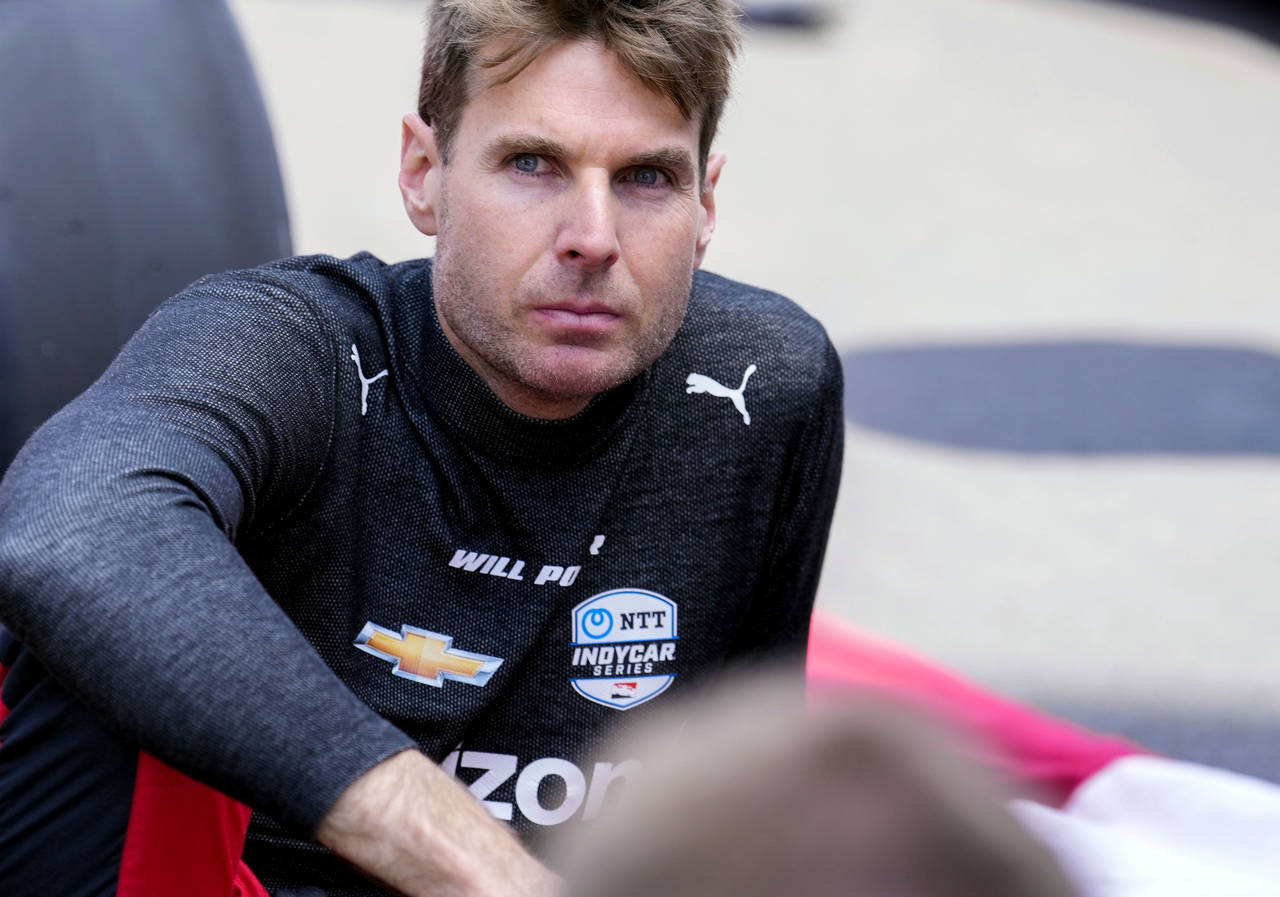 FILE - Will Power, of Australia, sits on the track before the Indianapolis 500 auto race at Indiana...