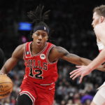 
              Chicago Bulls guard Ayo Dosunmu (12) drives as Toronto Raptors center Jakob Poeltl, right, defends during the first half of an NBA basketball game Tuesday, Feb. 28, 2023, in Toronto. (Frank Gunn/The Canadian Press via AP)
            