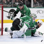
              Dallas Stars goaltender Jake Oettinger (29) is hit by a sliding Minnesota Wild's Jordan Greenway, bottom rear, as Oettinger defends against a shot during the second period of an NHL hockey game Wednesday, Feb. 8, 2023, in Dallas. Stars defenseman Miro Heiskanen is at rear. (AP Photo/Tony Gutierrez)
            