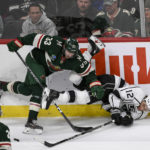 
              Minnesota Wild defenseman Alex Goligoski (33) checks Los Angeles Kings left wing Trevor Moore (12) into the boards during the first period of an NHL hockey game Tuesday, Feb. 21, 2023, in St. Paul, Minn. (AP Photo/Craig Lassig)
            