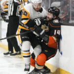 
              Anaheim Ducks' Adam Henrique (14) is checked by Pittsburgh Penguins' Mark Friedman (52) during the first period of an NHL hockey game Friday, Feb. 10, 2023, in Anaheim, Calif. (AP Photo/Jae C. Hong)
            