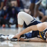 
              Denver Nuggets forward Michael Porter Jr. grabs his foot after being fouled while making a 3-point basket by Los Angeles Clippers guard Russell Westbrook in the second half of an NBA basketball game Sunday, Feb. 26, 2023, in Denver. Porter remained in the game. (AP Photo/David Zalubowski)
            