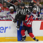 
              Washington Capitals right wing Nicolas Aube-Kubel (96) collides with linesman Steve Barton (59) during the third period of an NHL hockey game against the New York Rangers, Saturday, Feb. 25, 2023, in Washington. The Capitals won 6-3. (AP Photo/Julio Cortez)
            