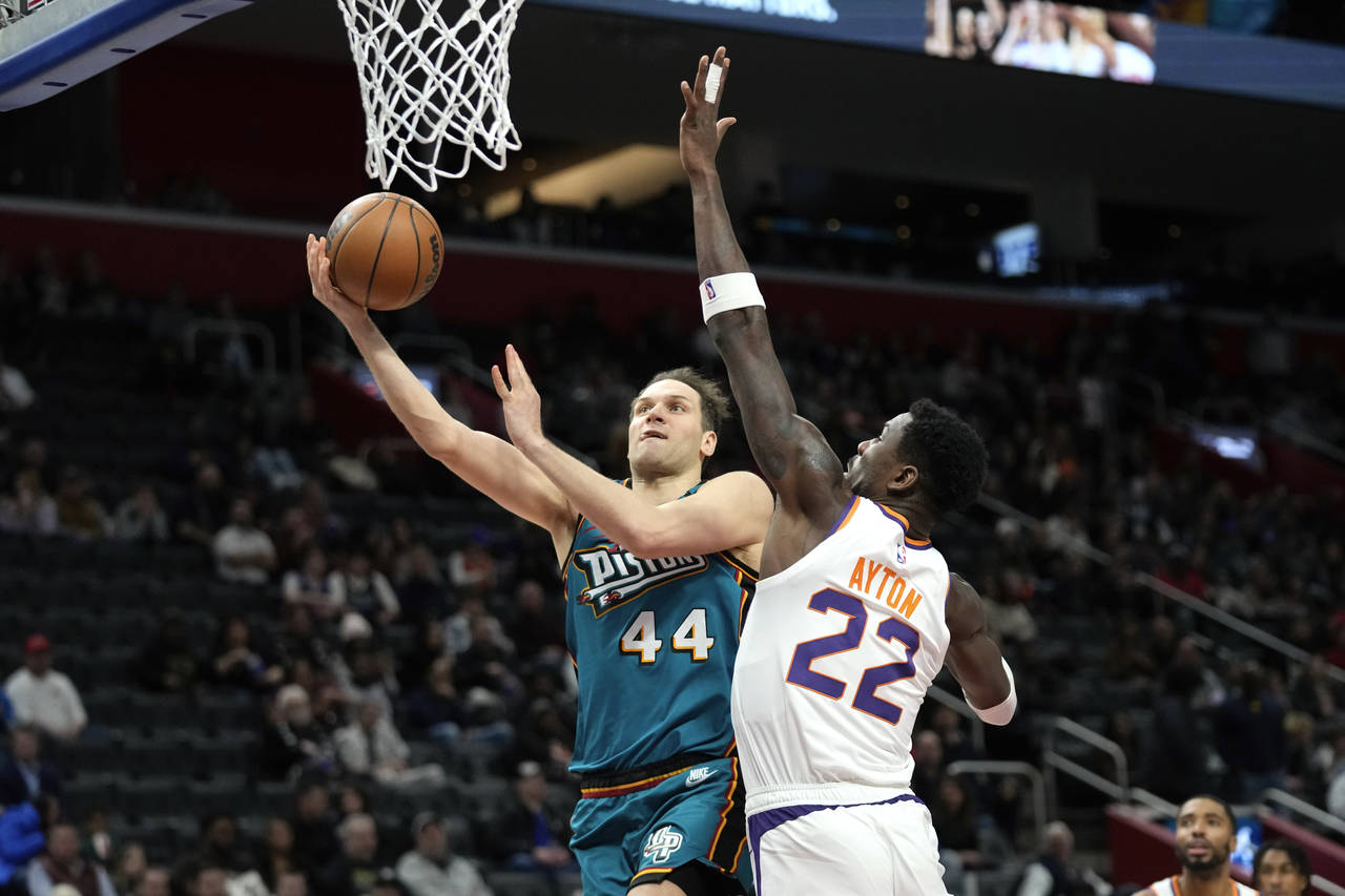 Detroit Pistons forward Bojan Bogdanovic (44) drives on Phoenix Suns center Deandre Ayton (22) in t...