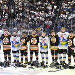 
              Team Ukraine Select and Boston Junior Bruins peewee teams stand together during the national anthems before their hockey game, Saturday, Feb. 11, 2023, in Quebec City. (Jacques Boissinot/The Canadian Press via AP)
            