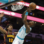 
              Charlotte Hornets guard Terry Rozier, right, shoots against Atlanta Hawks forward De'Andre Hunter (12) during the first half of an NBA basketball game in Charlotte, N.C., Monday, Feb. 13, 2023. (AP Photo/Nell Redmond)
            