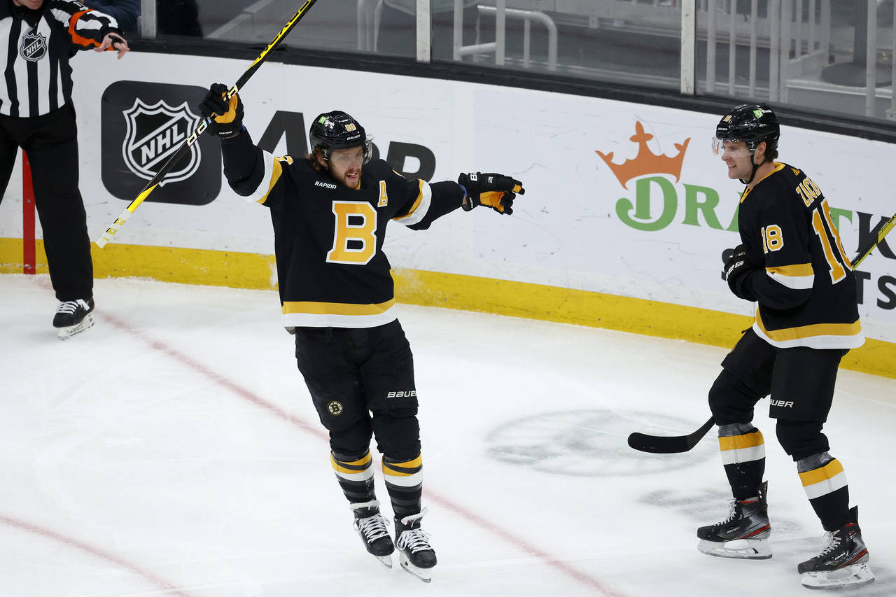 Boston Bruins right wing David Pastrnak celebrates with teammate Pavel Zacha (18) after scoring a g...